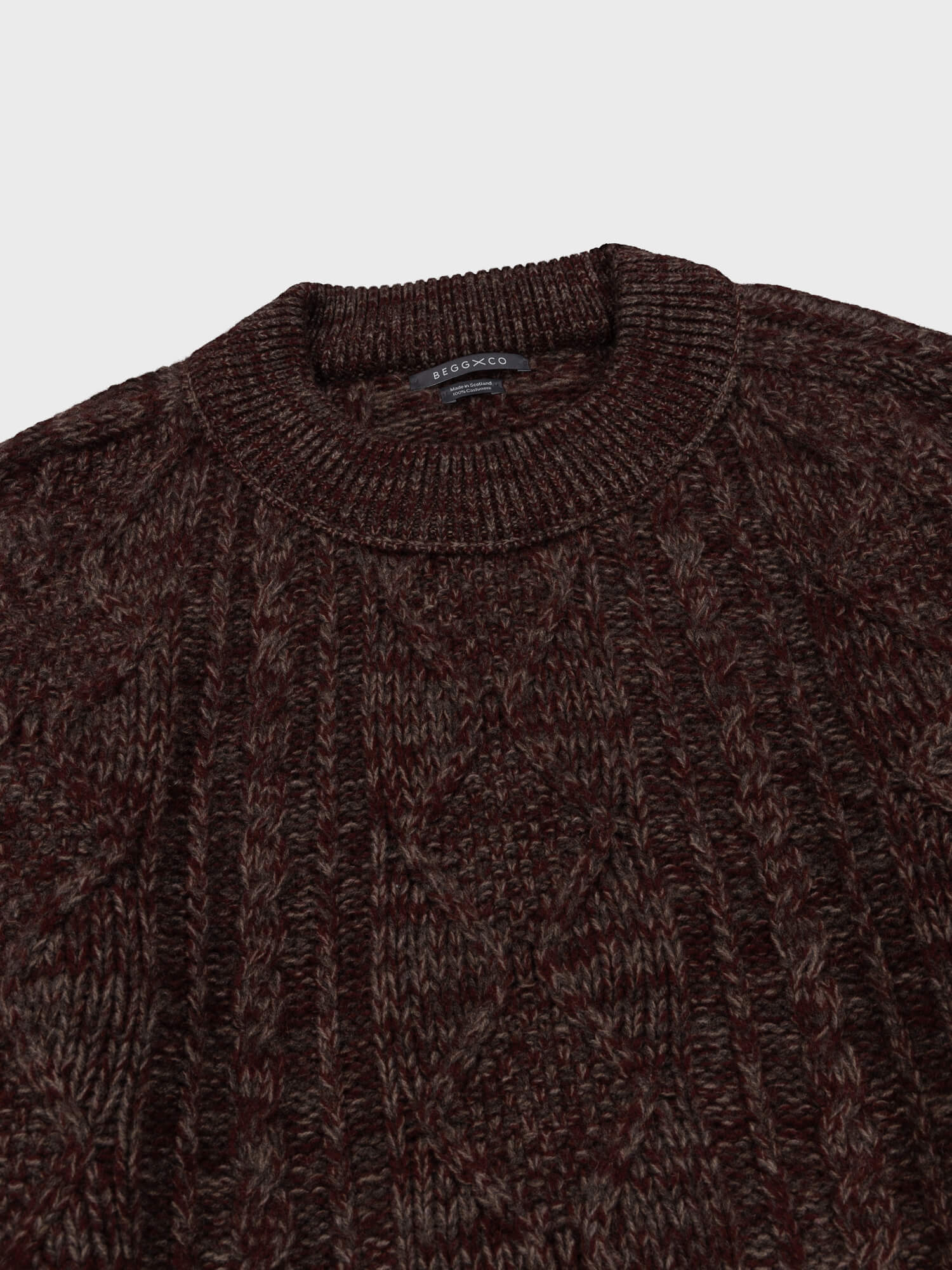 Brown and red knitted sweater on a light gray background