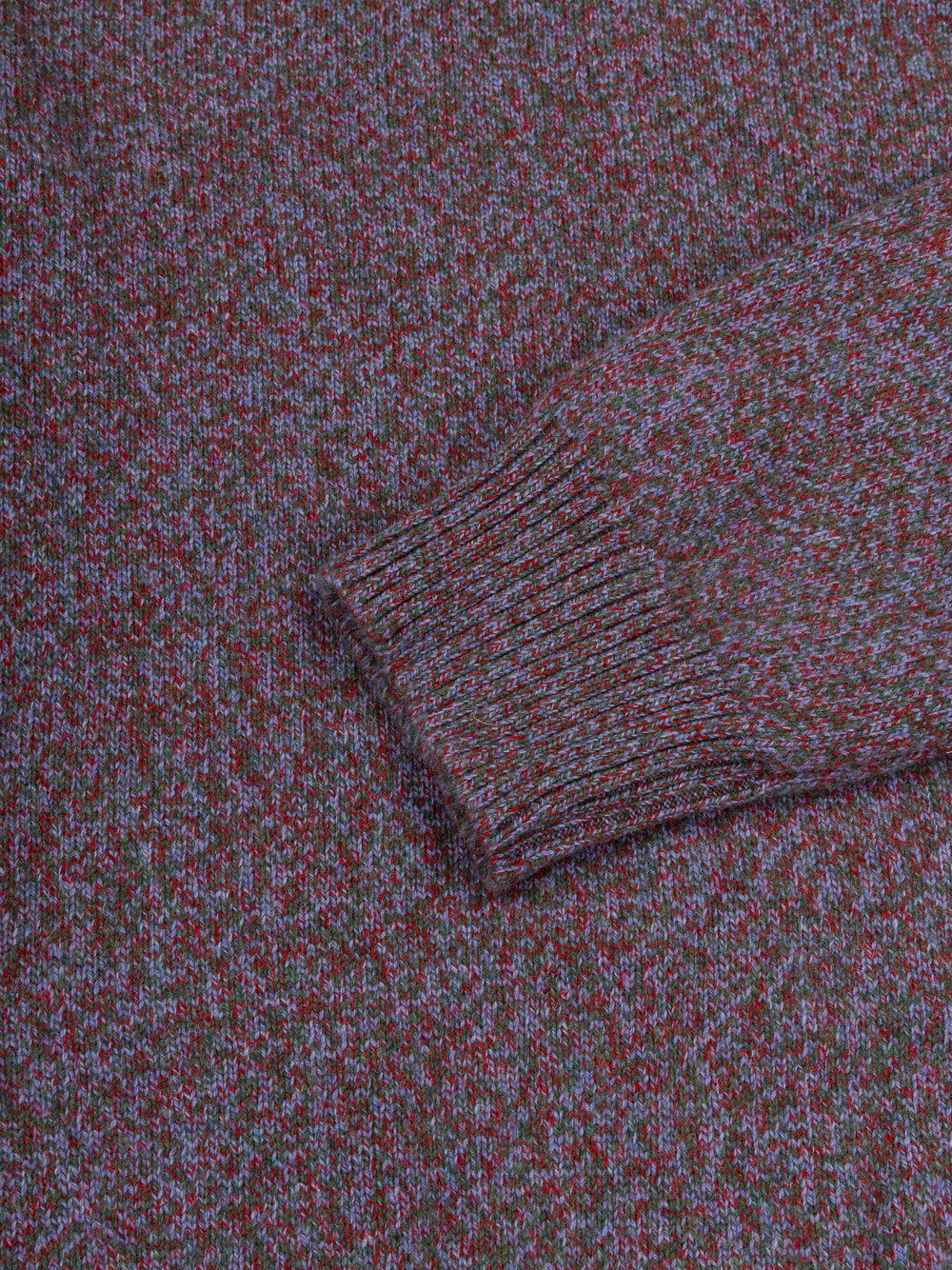 Close-up of a purple cashmere sweater with a patterned design.