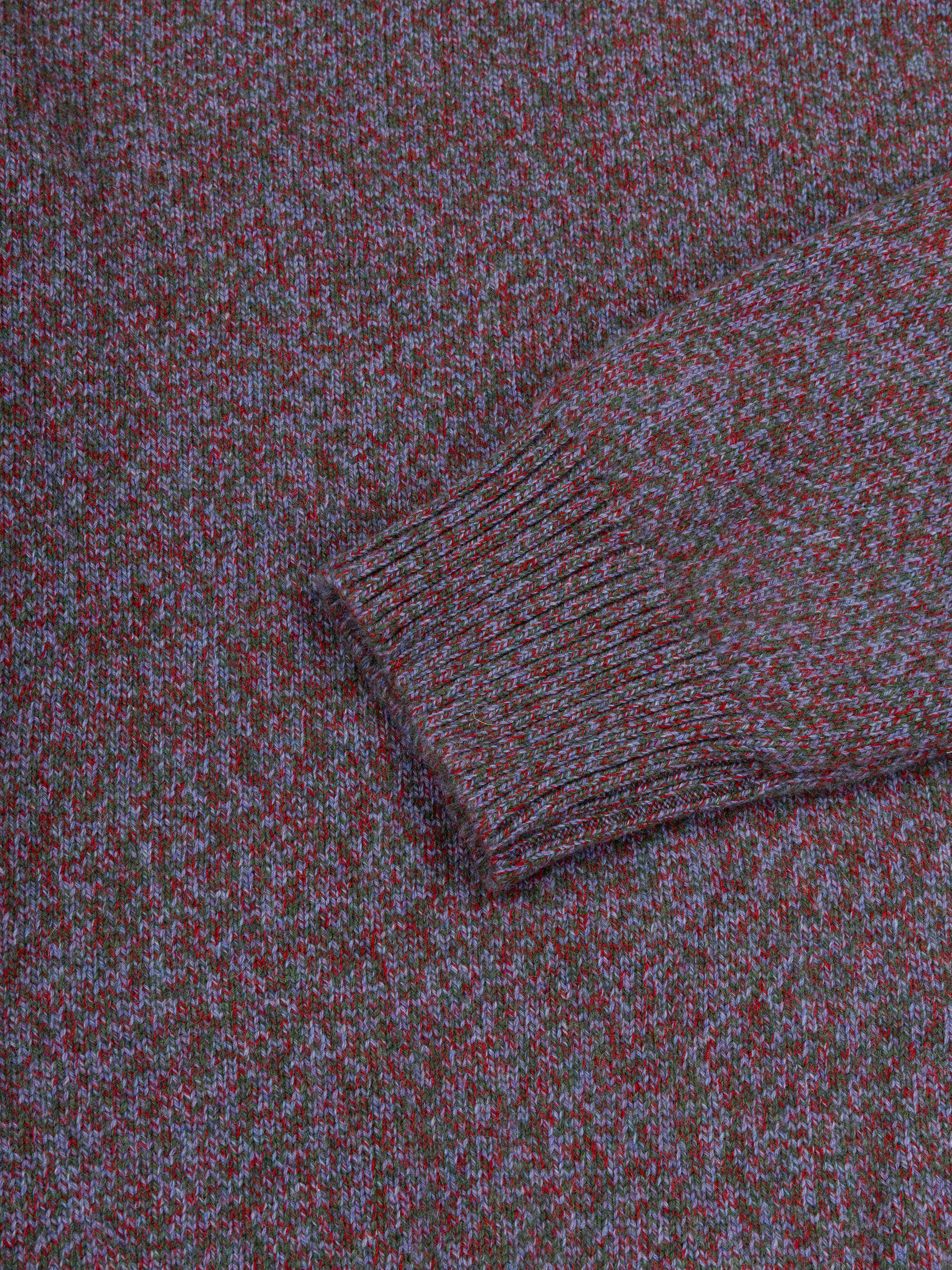 Close-up of a purple cashmere sweater with a patterned design.
