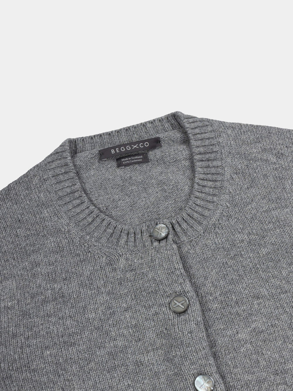 Gray cardigan with button details and Begg x Co label on a light gray background
