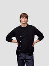 Man wearing a black cardigan with buttons on a light gray background