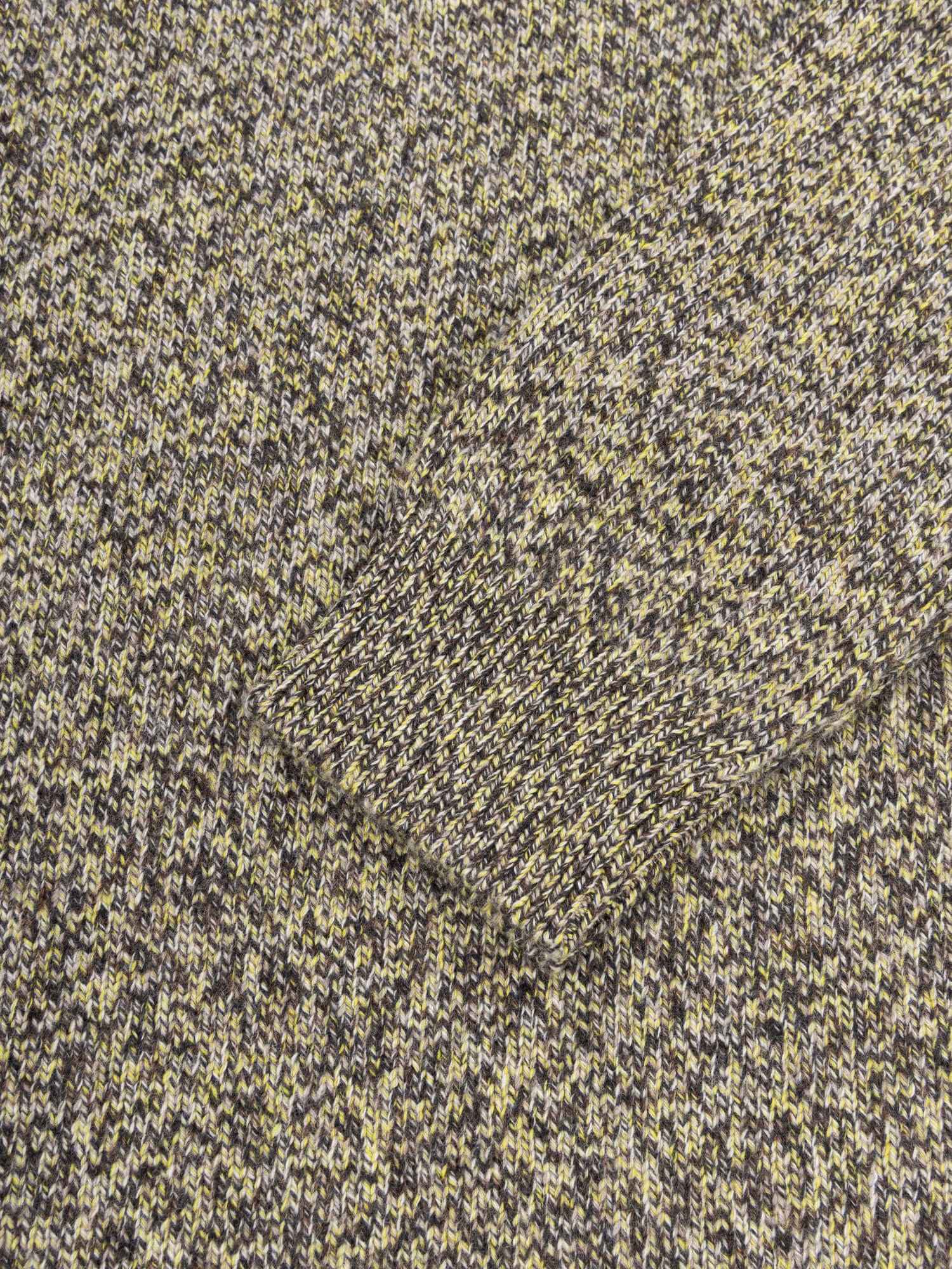 Close-up of textured fabric with a pattern of dark and light colors.