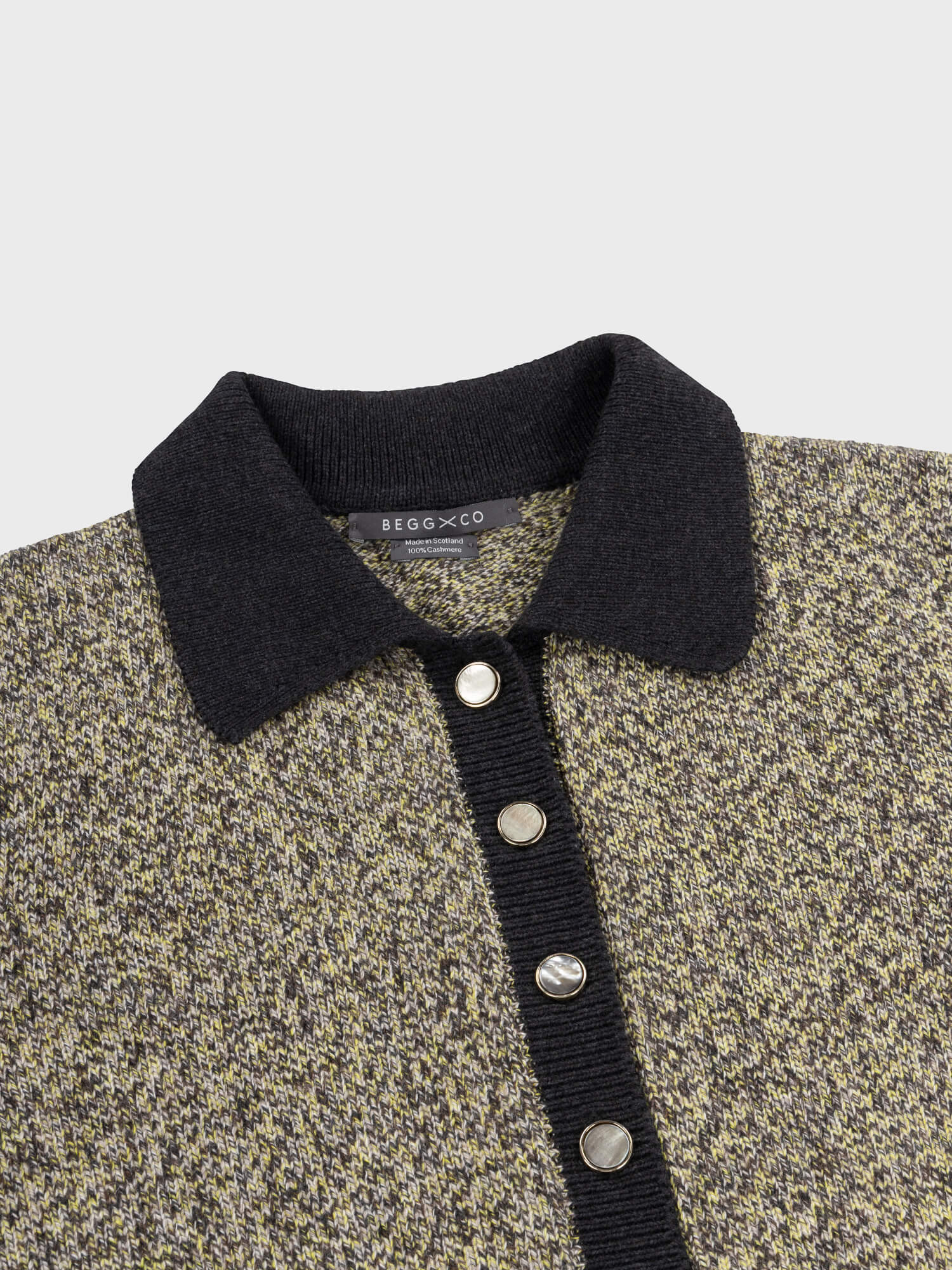 Textured sweater dress with black collar and buttons on a light gray background
