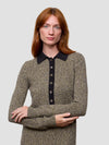 Woman wearing a patterned sweater dress with a black collar against a light gray background