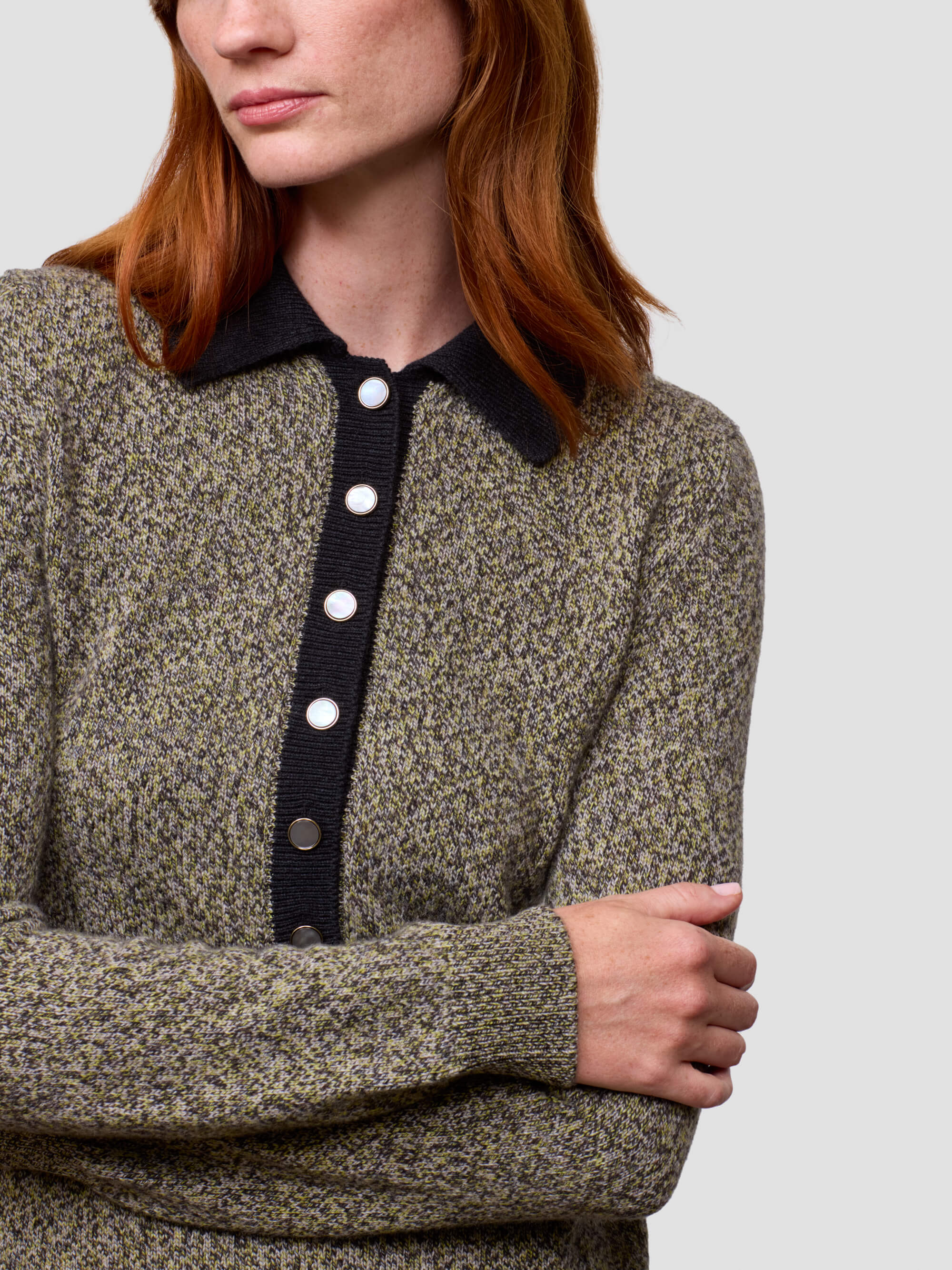 woman wearing a green cashmere sweater dress with button details
