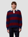 Man wearing a red and blue striped cashmere sweater over a white shirt on a light gray background