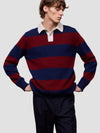 Man wearing a red and blue striped cashmere sweater over a white shirt on a light gray background