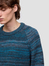 man wearing a blue and gray patterned cashmere sweater on a plain background