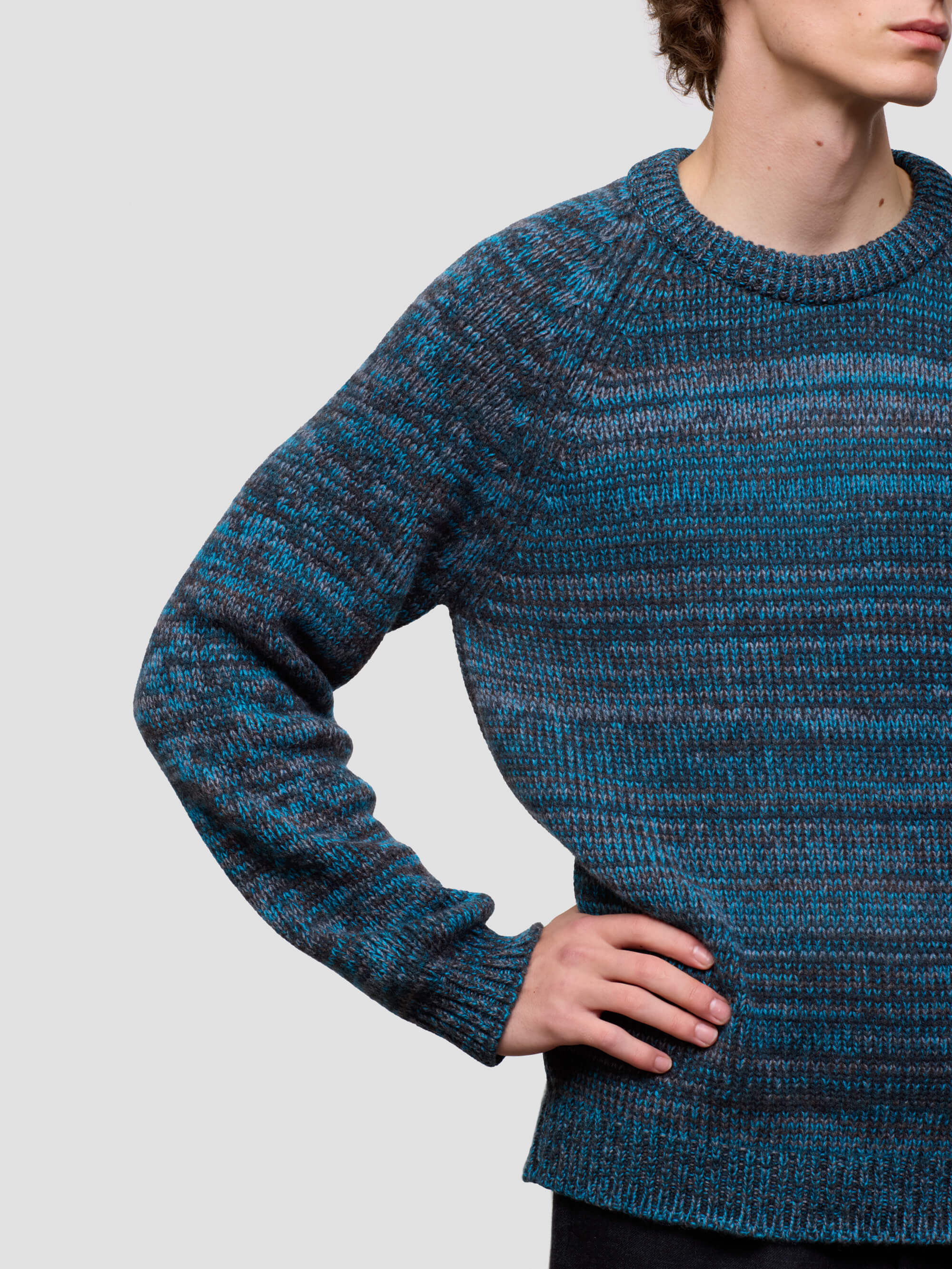 man wearing a blue cashmere knitted sweater on a plain background