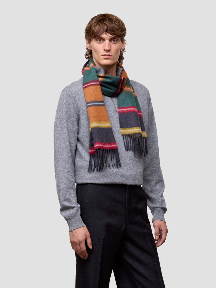 man wearing a colorful scarf and gray sweater on a white background