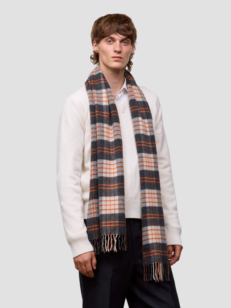 man wearing orange and grey tartan cashmere scarf and white v neck sweater