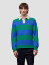 Man wearing a blue and green striped sweater with a white collar on a light gray background