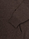 Close-up of a brown cashmere hoodie with a focus on the neckline and sleeve.
