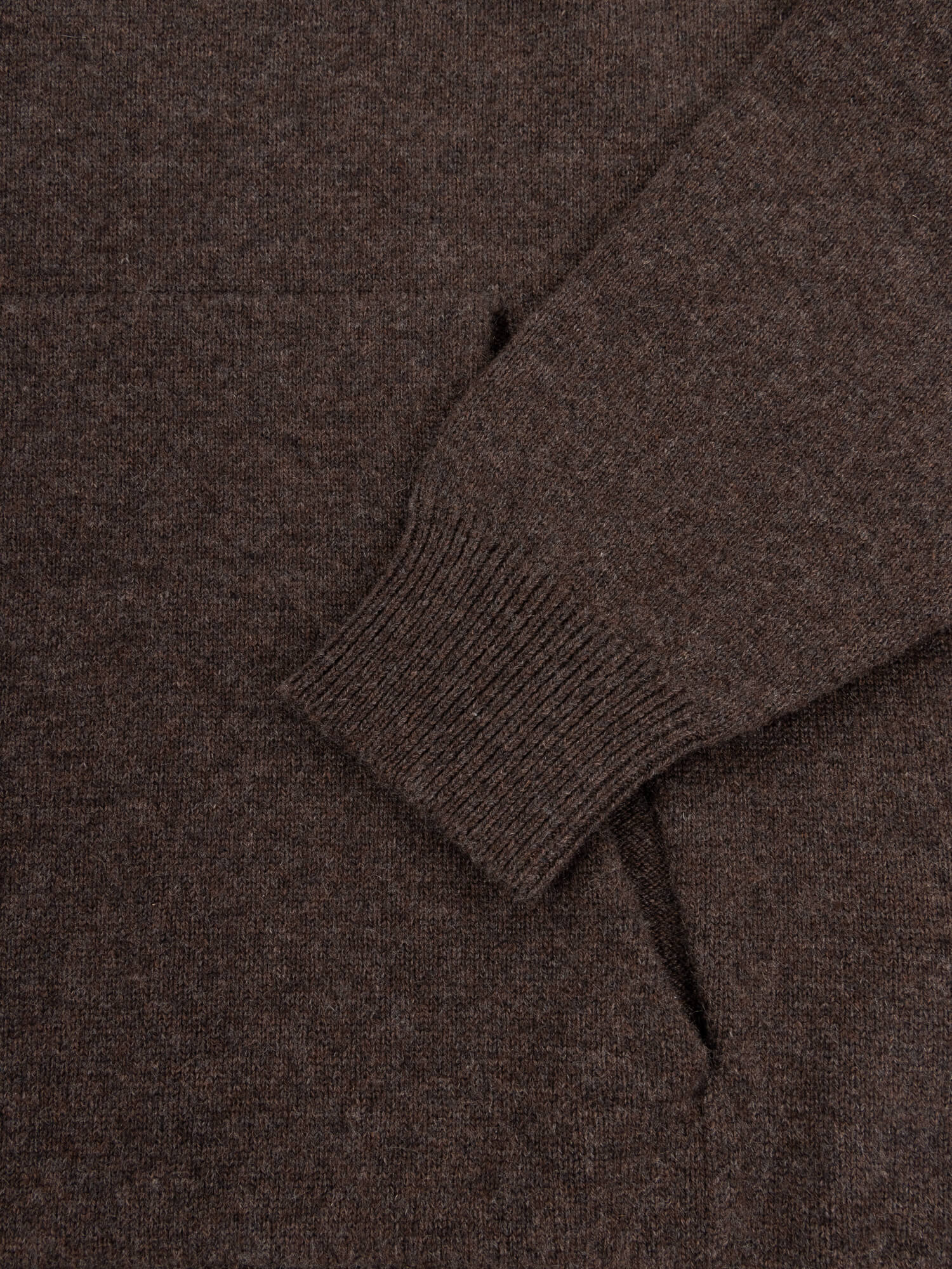 Close-up of a brown cashmere hoodie with a focus on the neckline and sleeve.