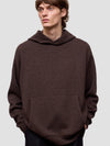 Man wearing a brown hoodie against a plain background