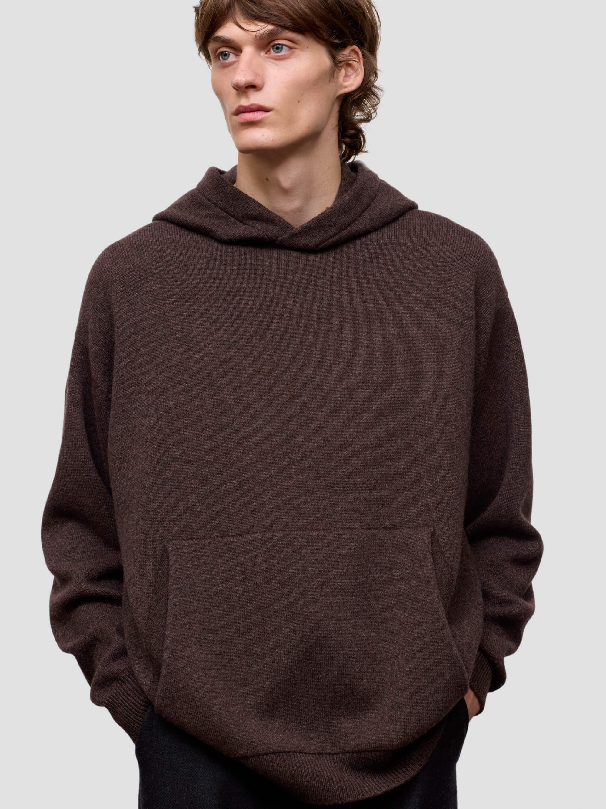 Man wearing a brown hoodie against a plain background