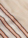 close up of a beige scarf with orange stripes