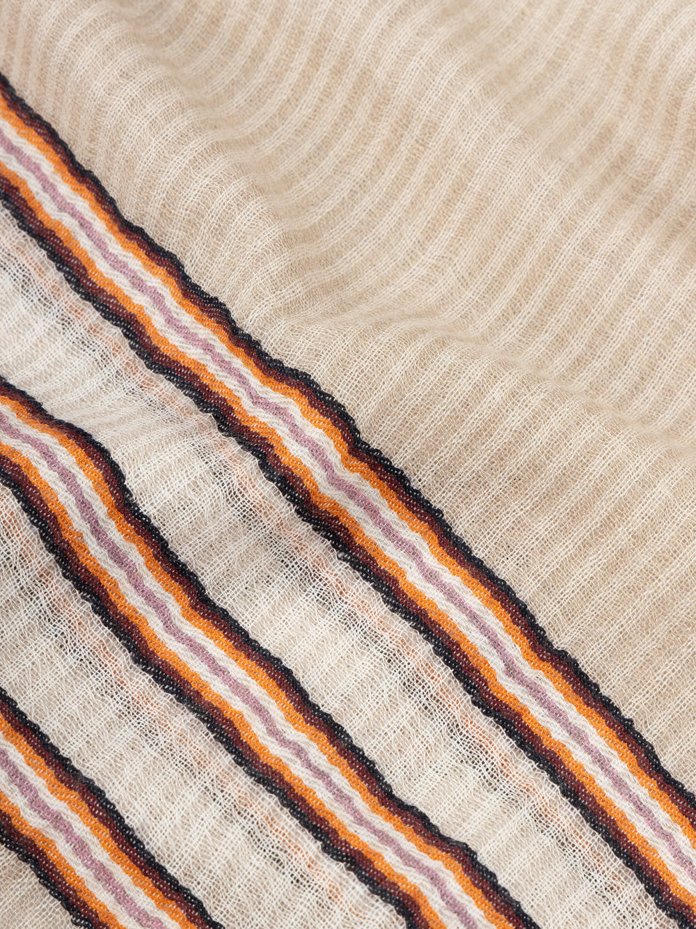close up of a beige scarf with orange stripes