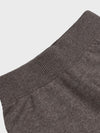 Close-up of a brown cashmere sweatpants with a textured pattern on a light gray background