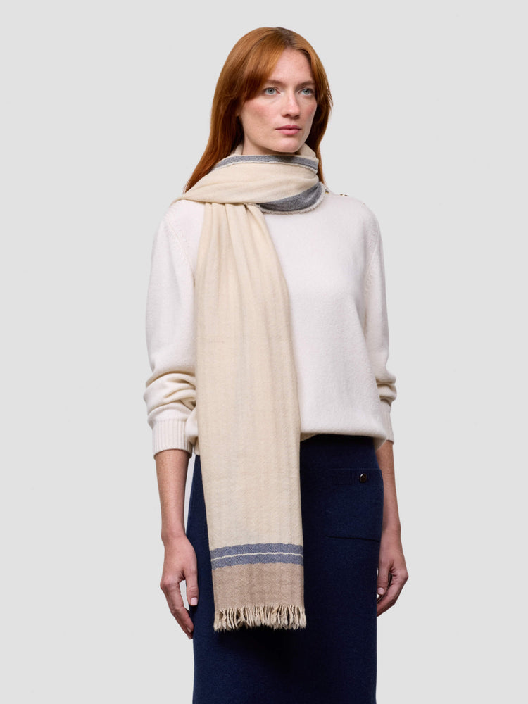 Woman wearing a beige scarf with a white background