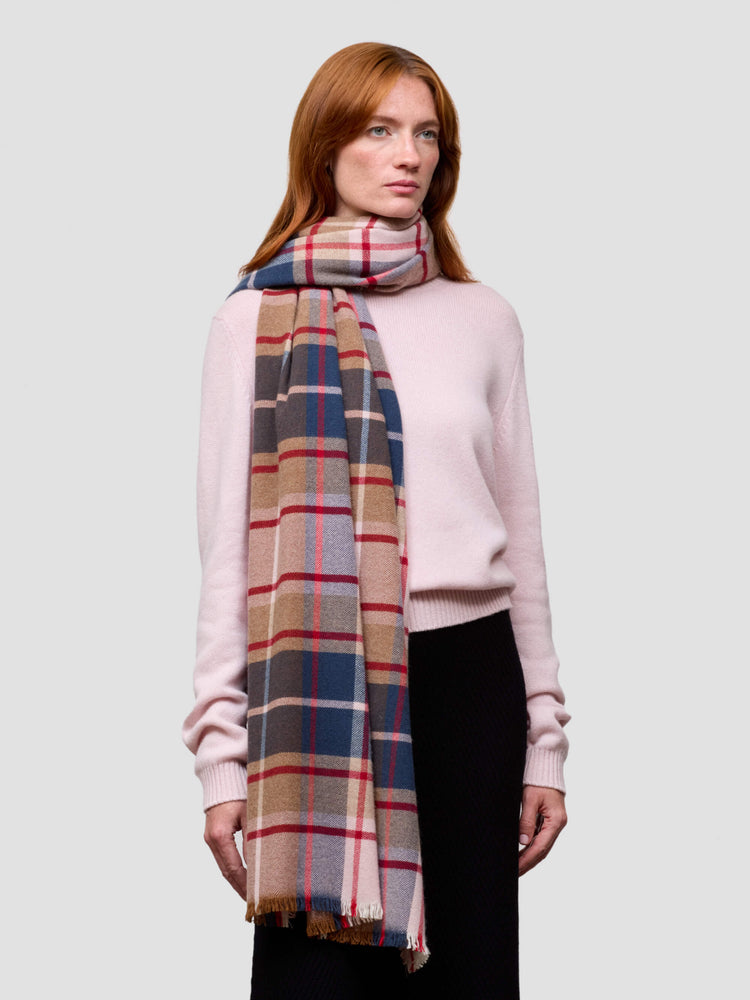 Woman wearing a plaid scarf and pink sweater on a white background